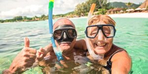 Active senior couple snorkeling in the ocean having a new adventure