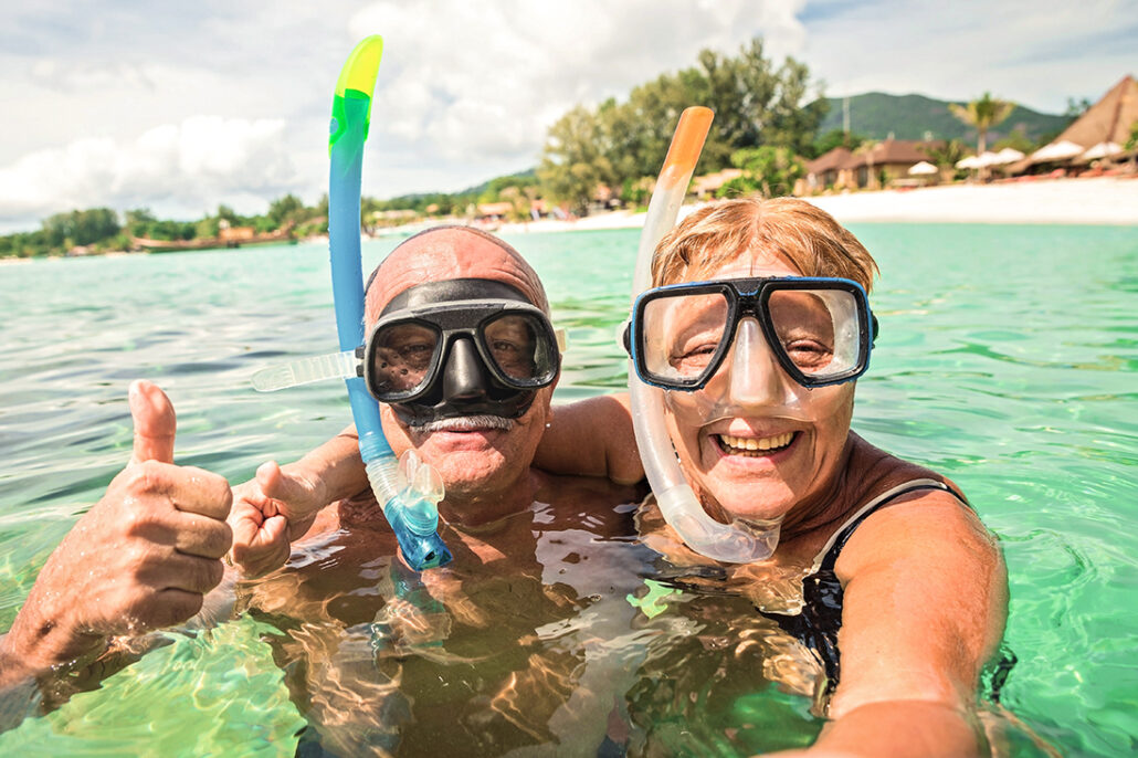 Active senior couple snorkeling in the ocean having a new adventure
