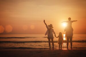 Happy young family on the beach at sunset, after screening for type 1 diabetes