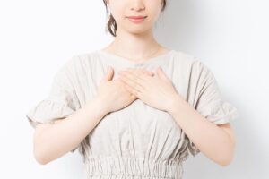 woman holds her heart with a feeling of piece after learning medical test results