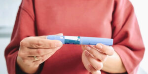 Woman holding a GLP-1 medication pen for diabetes and weight loss