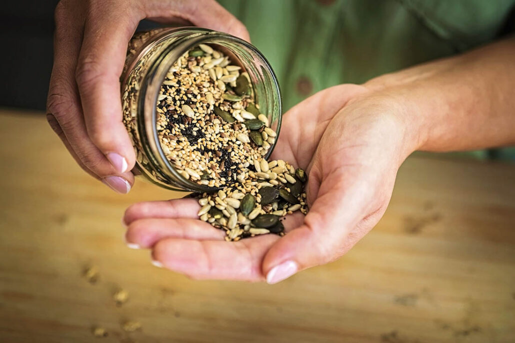 Someone pouring out a health snack of nuts and seeds