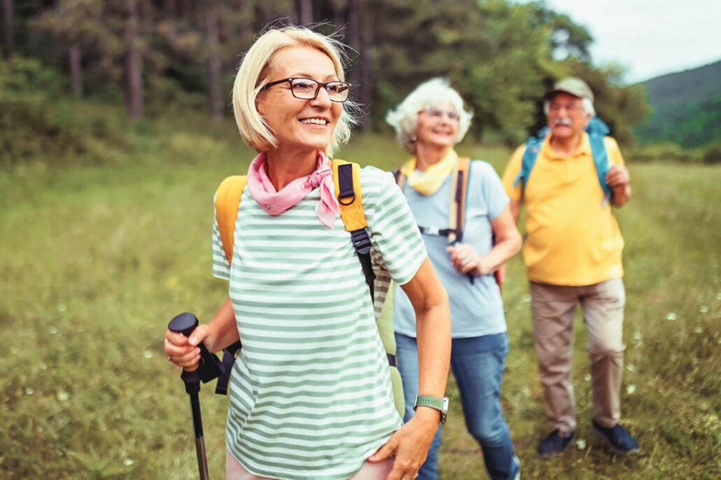 A small group of friends out on a walk together on a nature path near the woods