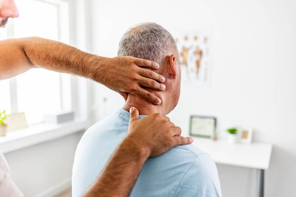man being examined by a doctor for a stiff neck