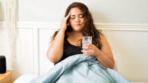 Woman sick in bed with a headache