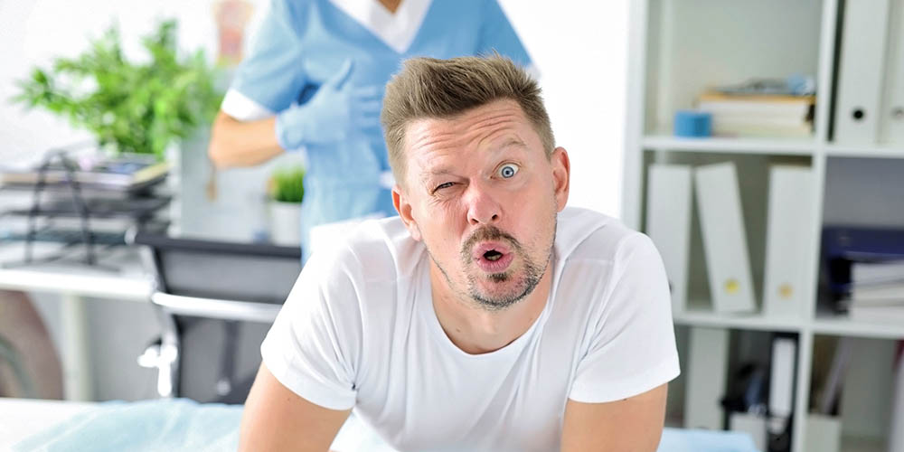 Man wincing during a prostate exam at the urologist's office