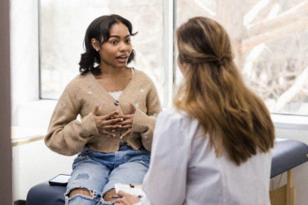 Patient calmly speaking to her doctor about her symptoms and what she needs