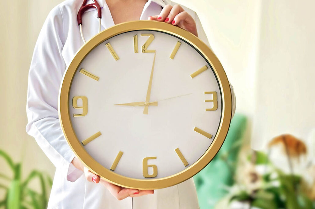 Doctor holding a clock to indicate a short appointment time