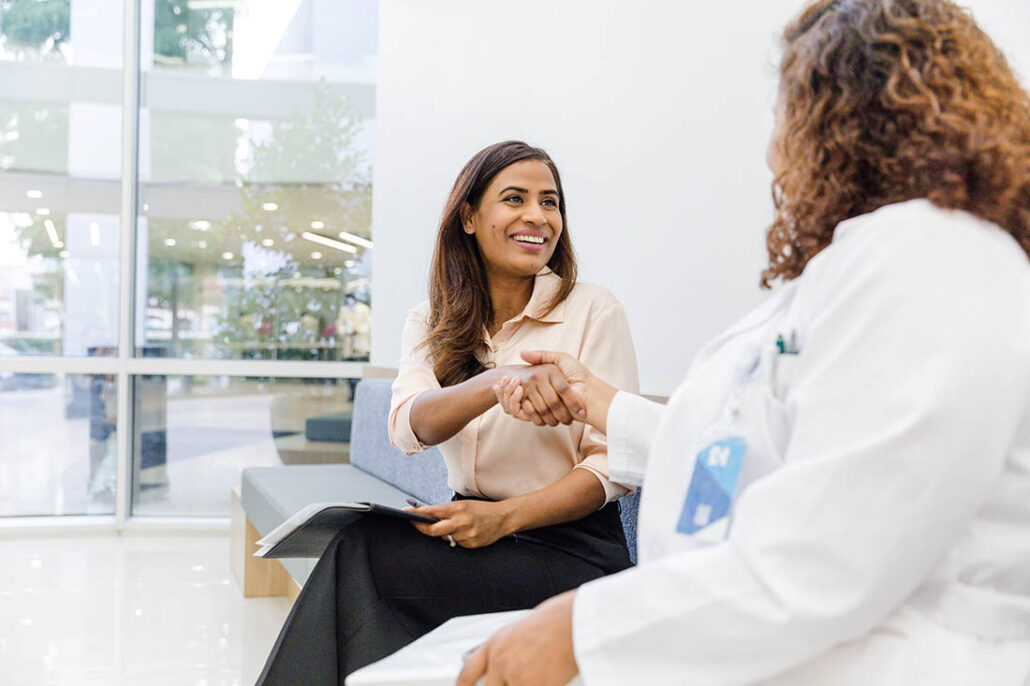 Patient with grateful smile giving a handshake of thanks to her doctor