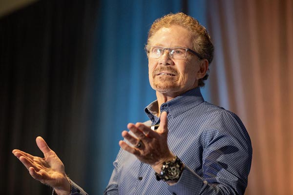 A male speaker on stage giving a talk